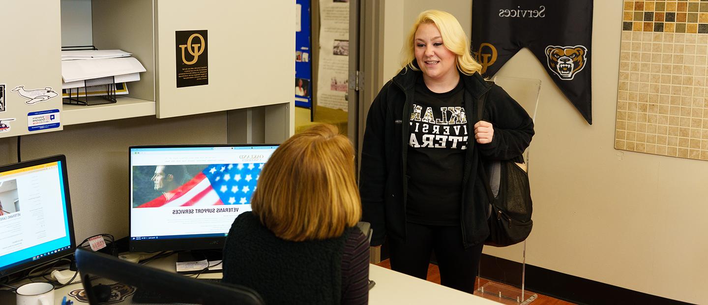 Young Woman in Oakland University Veteran speaks to a woman in the Veteran Support Services office